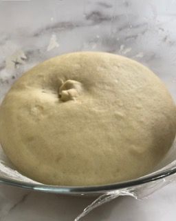 Primo piano di un impasto in una ciotola di vetro su un tavolo.