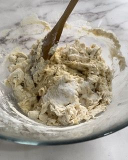 Una ciotola di impasto con un cucchiaio di legno dentro.