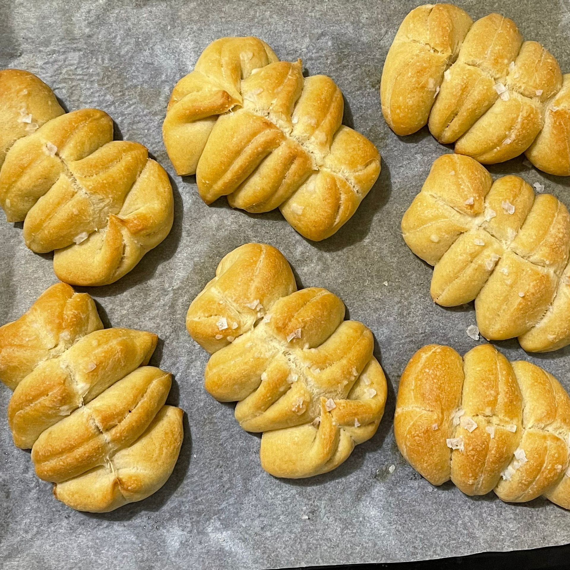 Un mucchio di panini sono appoggiati su un pezzo di carta oleata su un tavolo.