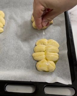 Una persona tiene in mano un pezzo di pasta su un vassoio