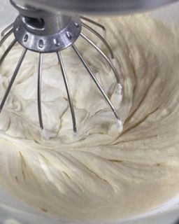 Un primo piano di un mixer con panna montata al suo interno.