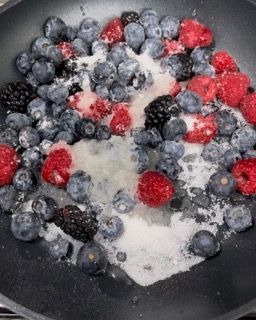 Una padella piena di mirtilli lamponi e more