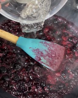 Una spatola blu viene versata in una ciotola di bacche