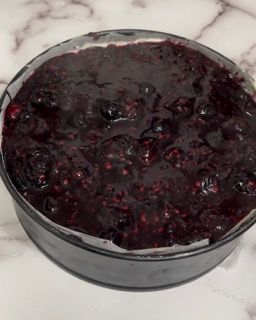Una ciotola di salsa di frutti di bosco è appoggiata su un tavolo.