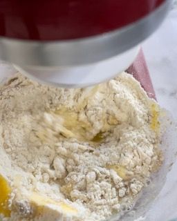 Un mixer mescola farina e burro in una ciotola.