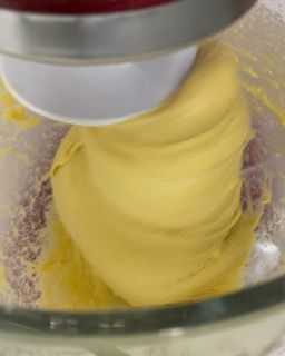 Un mixer sta mescolando un liquido giallo in una ciotola di vetro.