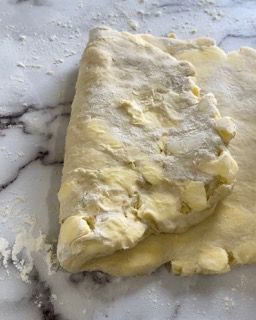 Un pezzo di pasta è appoggiato su un bancone di marmo.