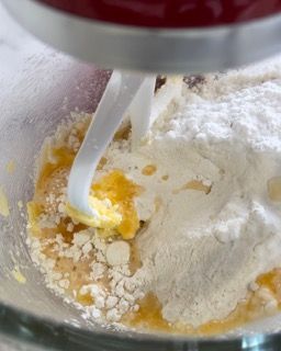 Un mixer mescola farina e burro in una ciotola di vetro.