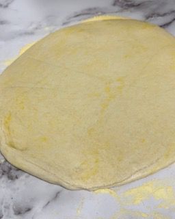 Un pezzo di pasta è appoggiato su una superficie di marmo.