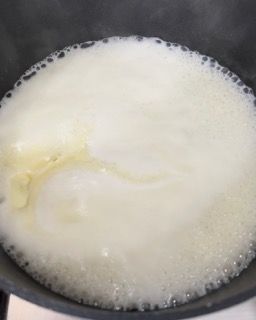 Primo piano di una pentola piena di liquido bianco.