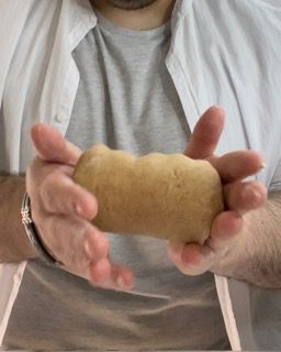 Un uomo tiene in mano un pezzo di pasta.