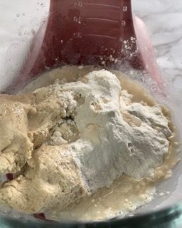 Primo piano di un frullatore pieno di gelato e di un misurino.
