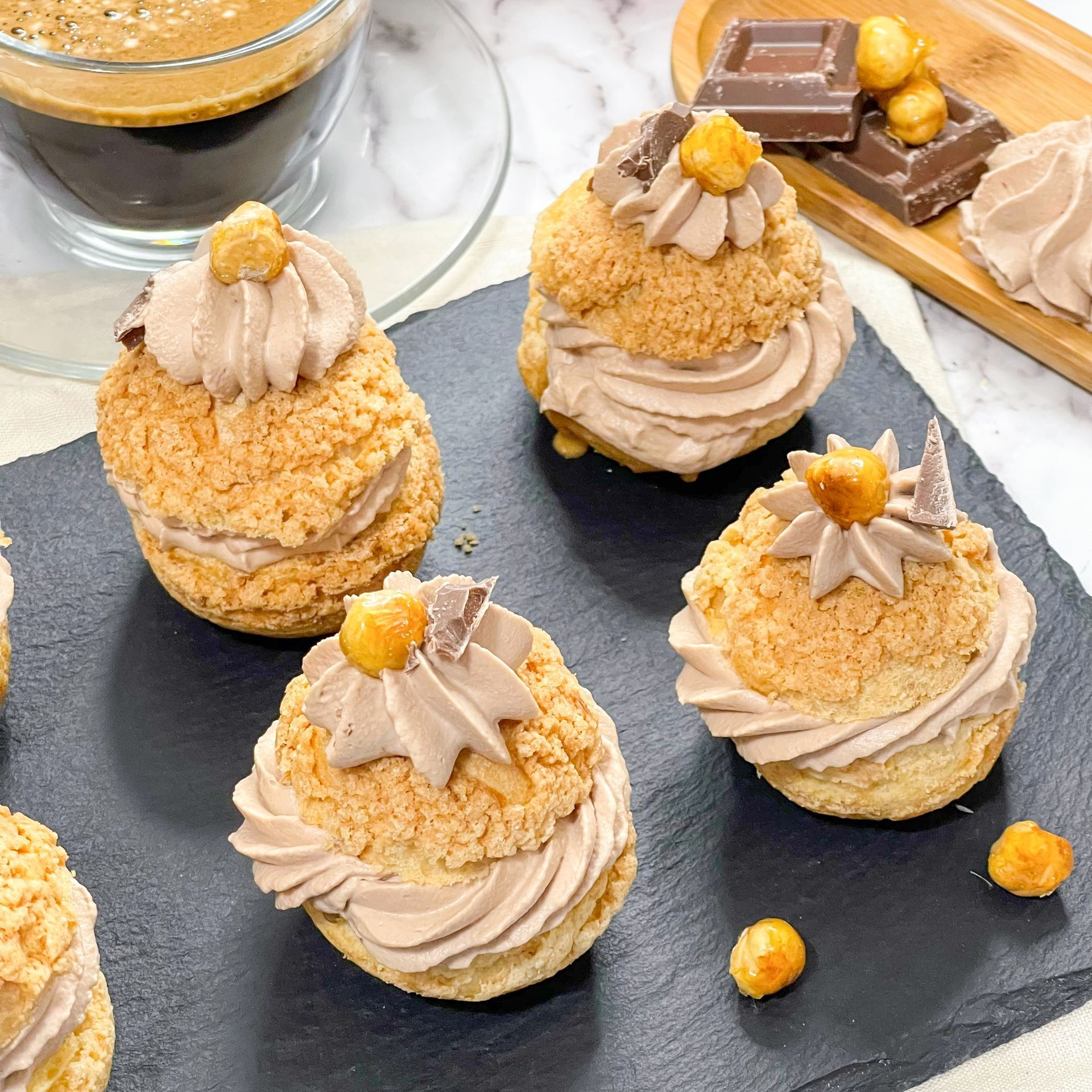 Un tavolo apparecchiato con dei dolcetti e una tazza di caffè.