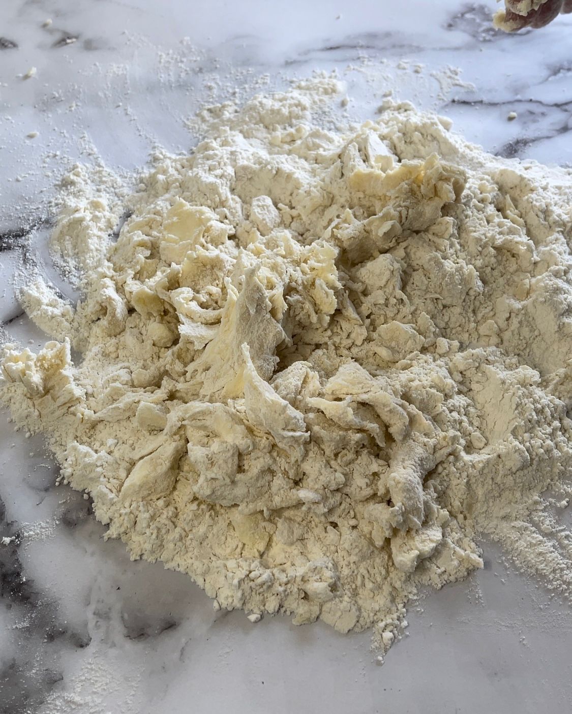 Un mucchio di farina è appoggiato su una superficie di marmo.