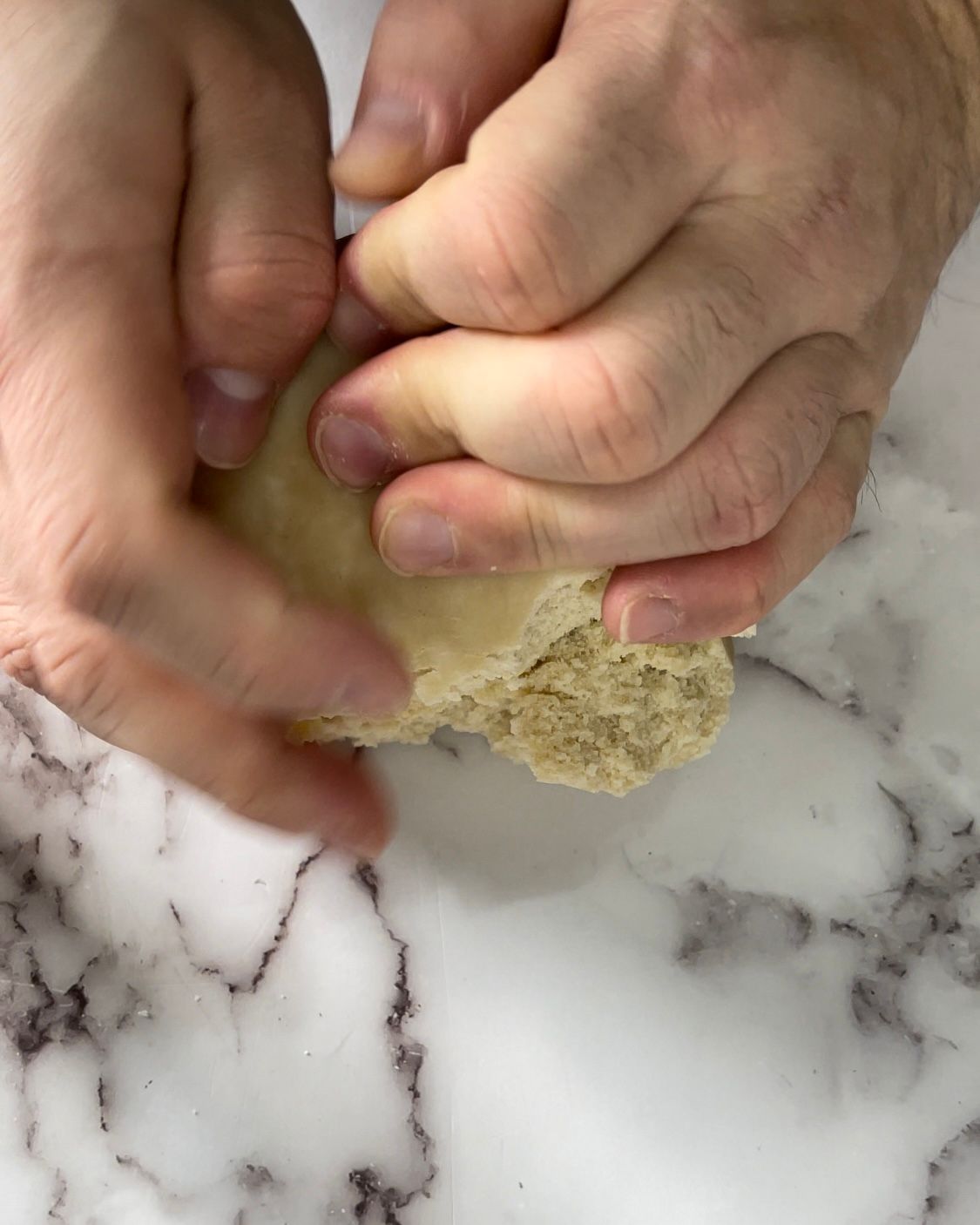 Una persona tiene in mano un pezzo di pasta.