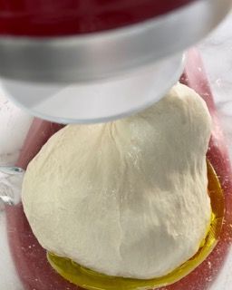 Una palla di pasta viene mescolata in un'impastatrice