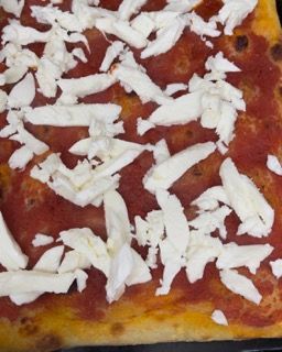 Una pizza con salsa di pomodoro e formaggio grattugiato sopra