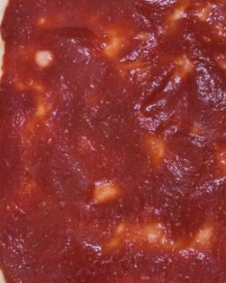 Un primo piano di una salsa di pomodoro su una pizza