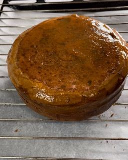 Una torta marrone è appoggiata su una griglia di raffreddamento