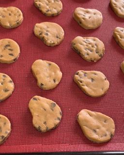 Un vassoio di biscotti con gocce di cioccolato su un tappetino rosso