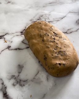 Un pezzo di pane è appoggiato su una superficie di marmo.