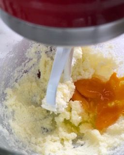 Un mixer mescola un impasto con un cucchiaio in una ciotola.