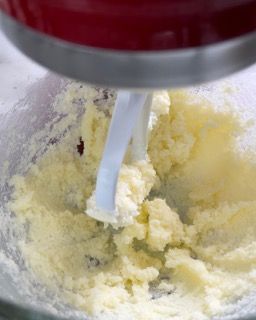 Un mixer sta mescolando il burro in una ciotola di vetro.