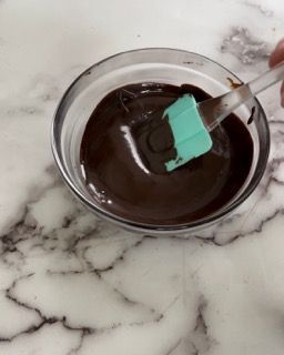 Una ciotola di salsa al cioccolato con una spatola dentro