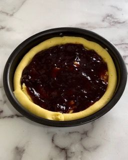 Una torta in una teglia con sopra la marmellata
