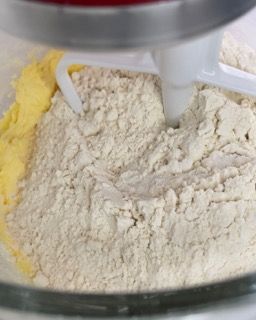 Un mixer mescola farina e burro in una ciotola di vetro.