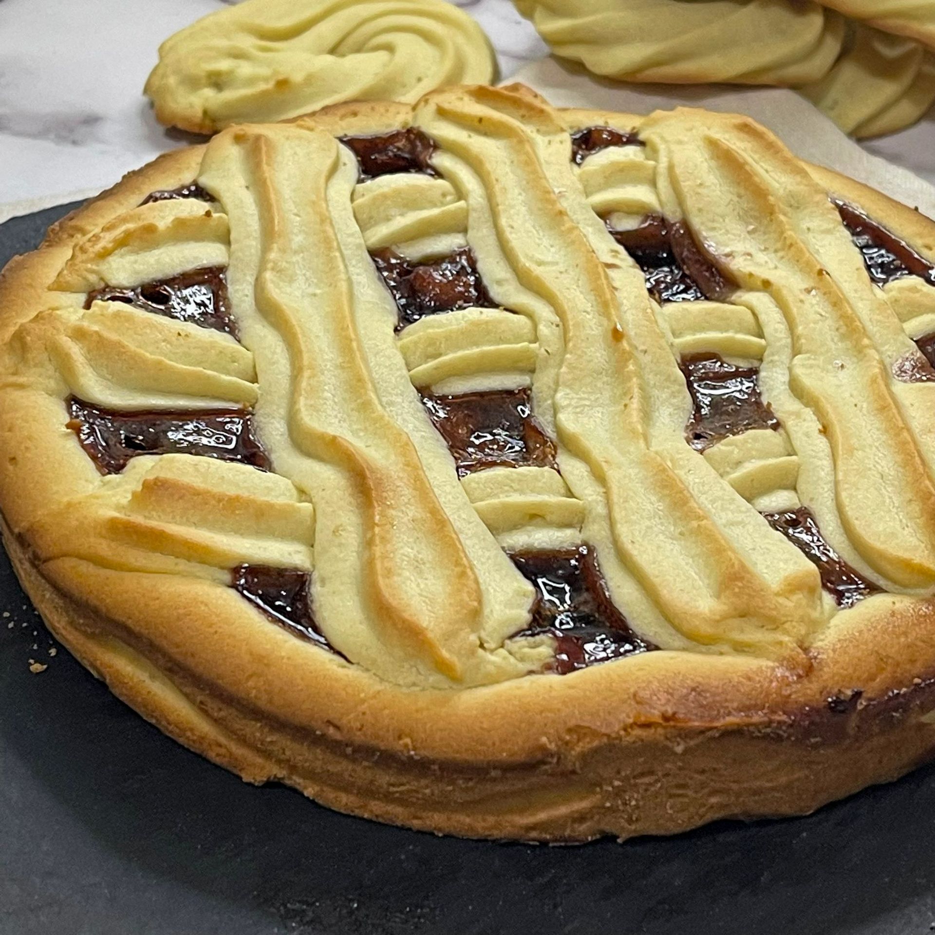 Una torta con una crosta a traliccio è appoggiata su un tavolo