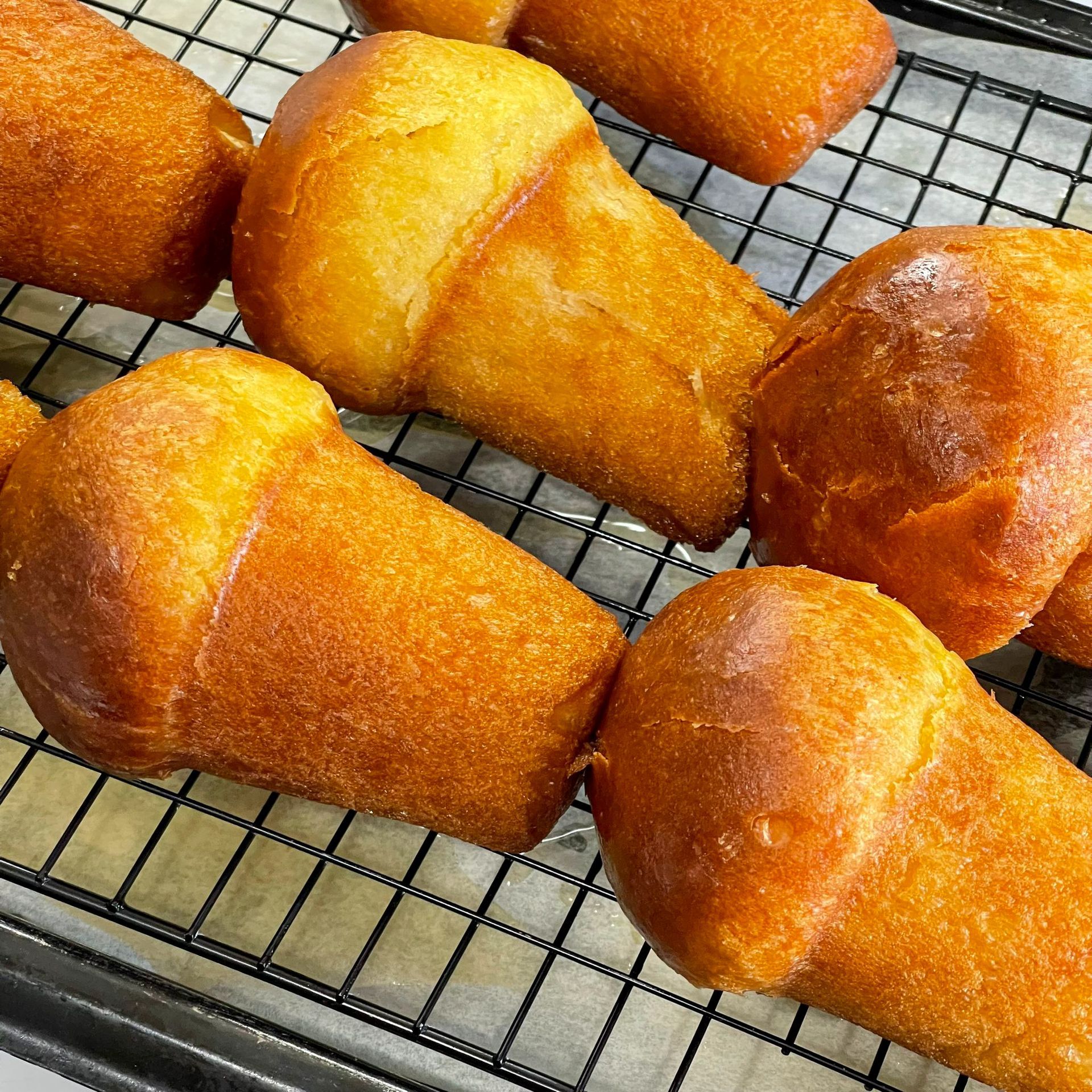 Un mucchio di pane è appoggiato su una griglia di raffreddamento.