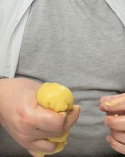 Una persona stringe un oggetto giallo tra le mani.