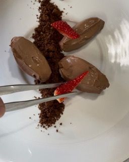 Una persona tiene un paio di pinzette sopra un piatto di cibo