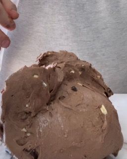 Una persona sta tagliando un pezzo di torta al cioccolato