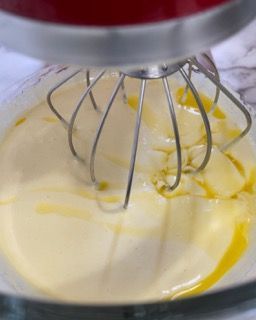 Burro fuso tiepido versato a filo nel composto di uova per la torta di mele.
