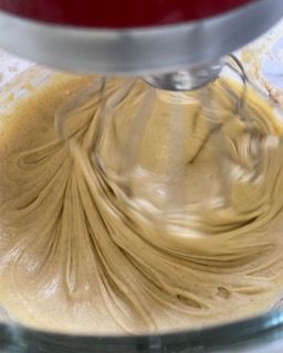 Latte versato nell'impasto mentre le fruste elettriche continuano a mescolare