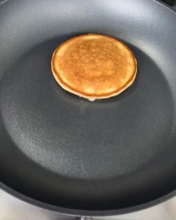 Una frittella viene cotta in una padella.