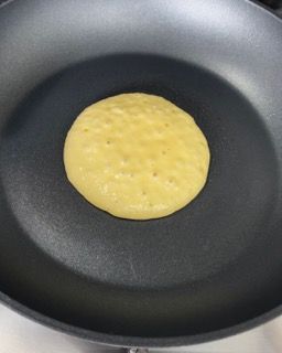 Una frittella viene cotta in una padella sul fornello.
