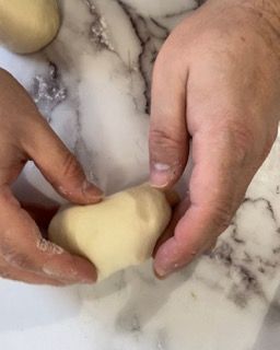 Una persona tiene in mano un pezzo di pasta.