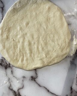 Un pezzo di pasta è appoggiato su una superficie di marmo.