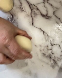 Una persona tiene in mano una palla di pasta.