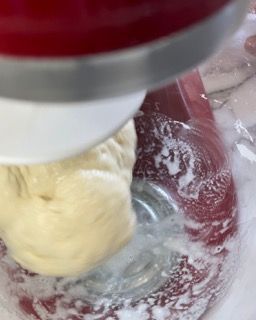 Primo piano di un mixer con una ciotola di pastella al suo interno.