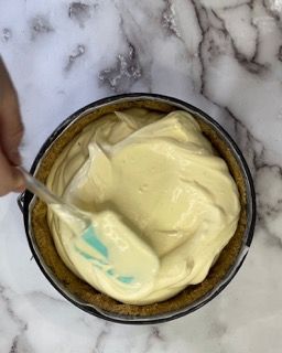 Una persona sta mescolando un liquido giallo in una ciotola con una spatola.