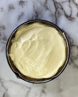 Una ciotola di maionese è appoggiata su una superficie di marmo.
