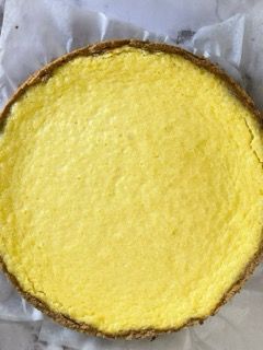 Una crosta di torta gialla è appoggiata su un pezzo di carta oleata.