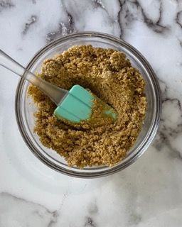 Una ciotola di zucchero di canna con una spatola dentro.