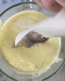 Una persona sta versando un cucchiaio in una ciotola di zuppa.