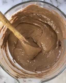 Una ciotola di salsa al cioccolato con un cucchiaio di legno dentro