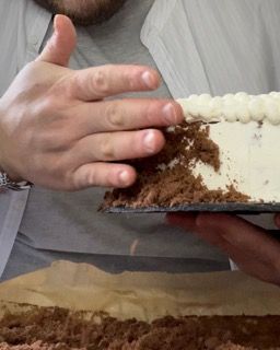 Un uomo sta tagliando una torta con una spatola